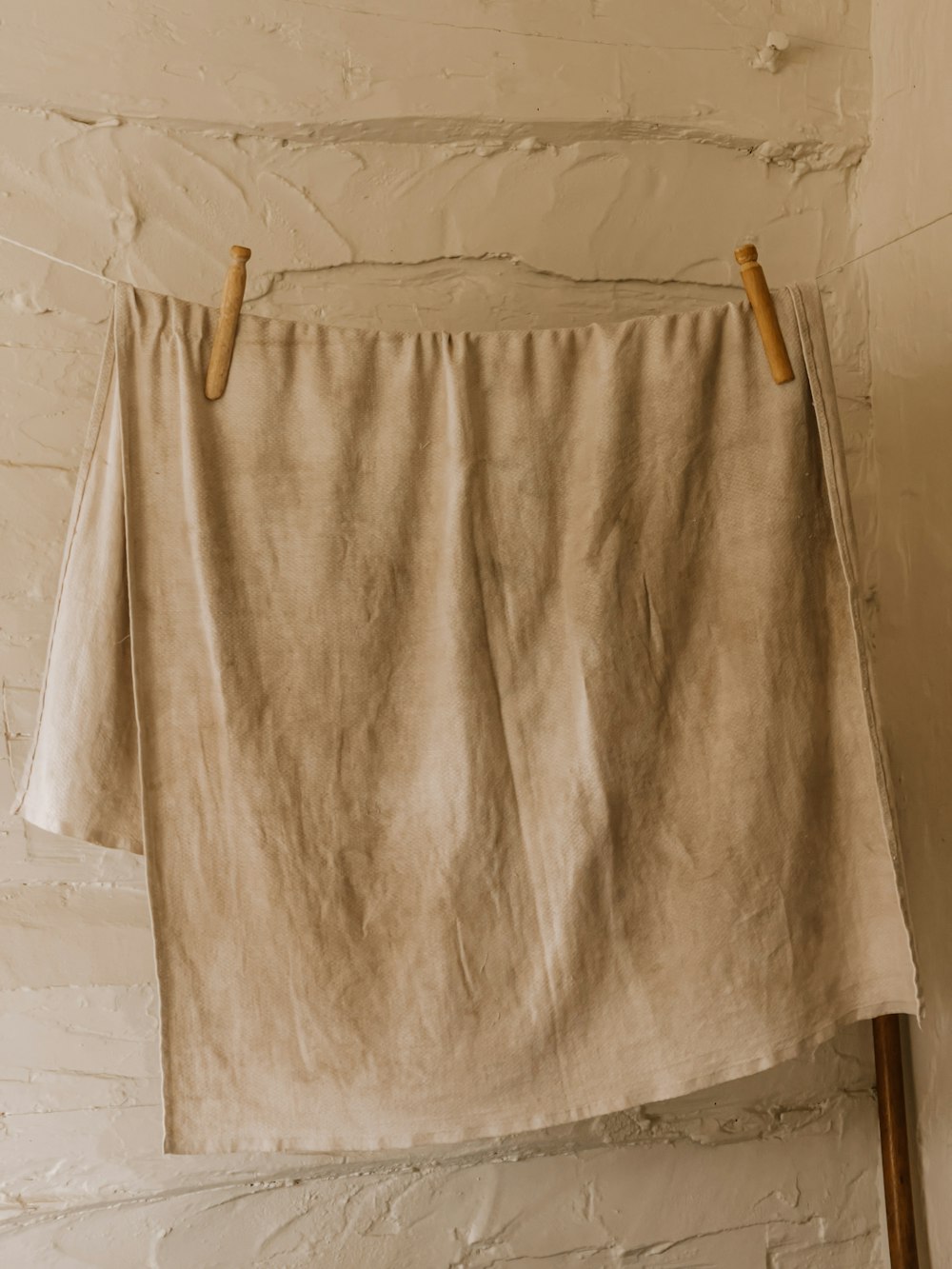 white bath towel on brown wooden clothes hanger
