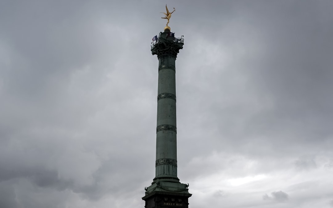 black and white statue under white clouds during daytime