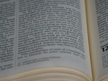 A close-up view of an open book displaying text with a focus on specific lines that are centrally aligned. The text appears to be in English and the page layout suggests it is part of a larger document or book. The edges of the pages are slightly blurred, drawing attention to the middle section.
