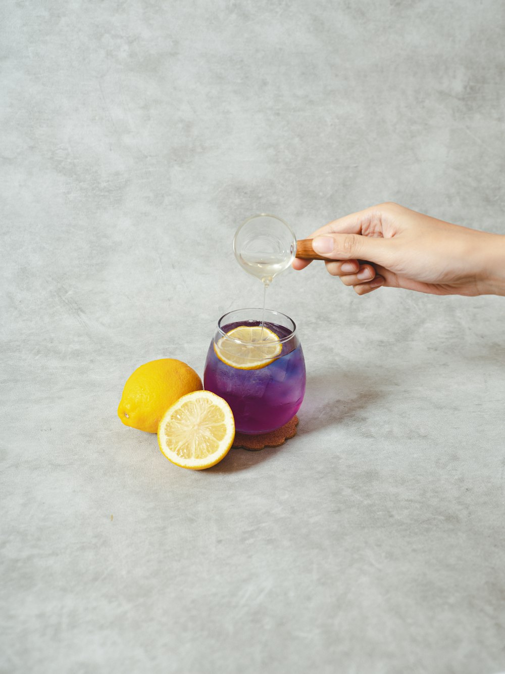 Persona che tiene una tazza di vetro trasparente con succo d'arancia