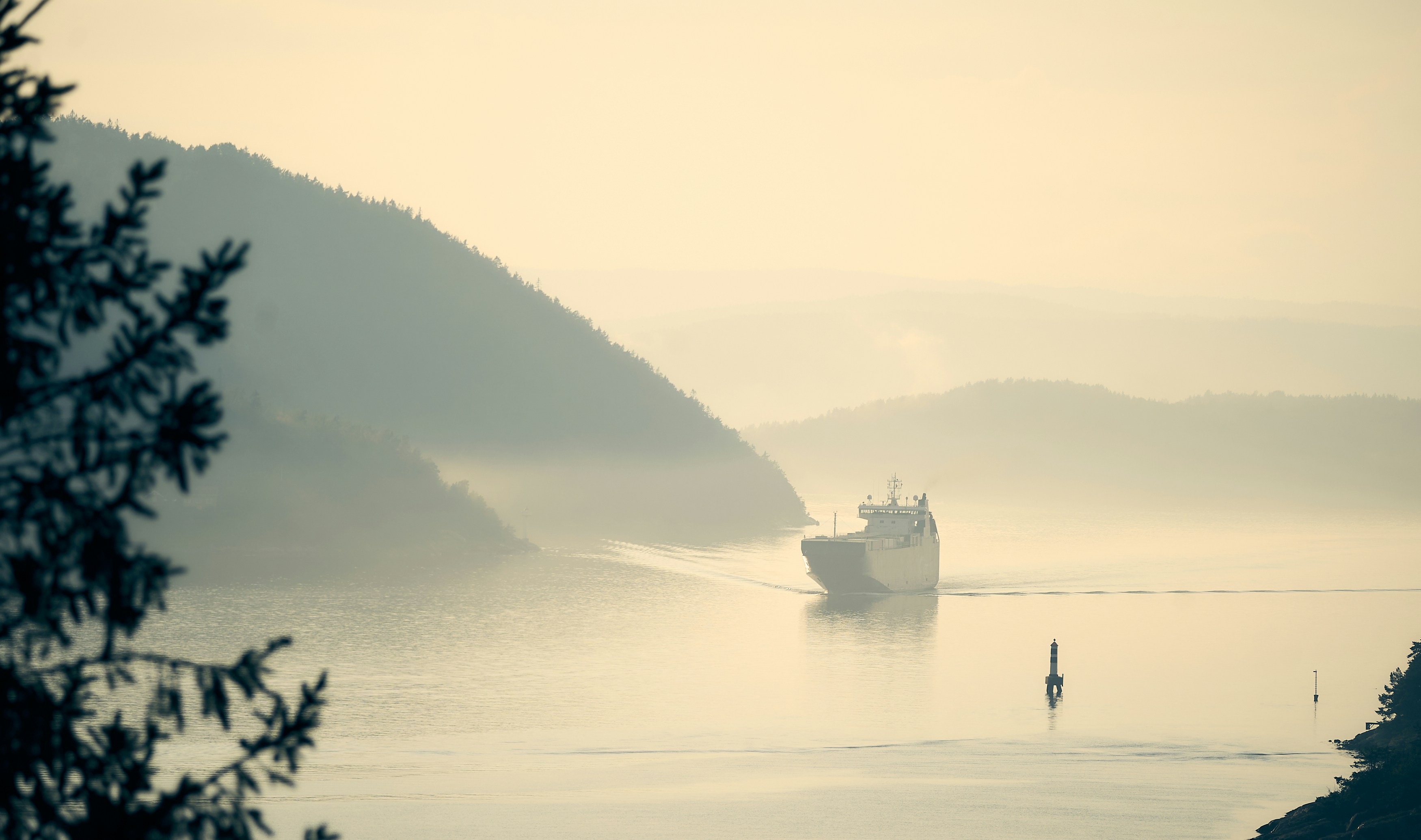 white boat on body of water during foggy weather