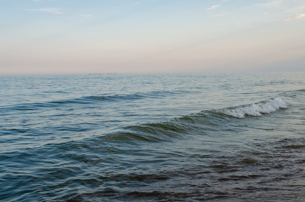 ocean waves under blue sky during daytime