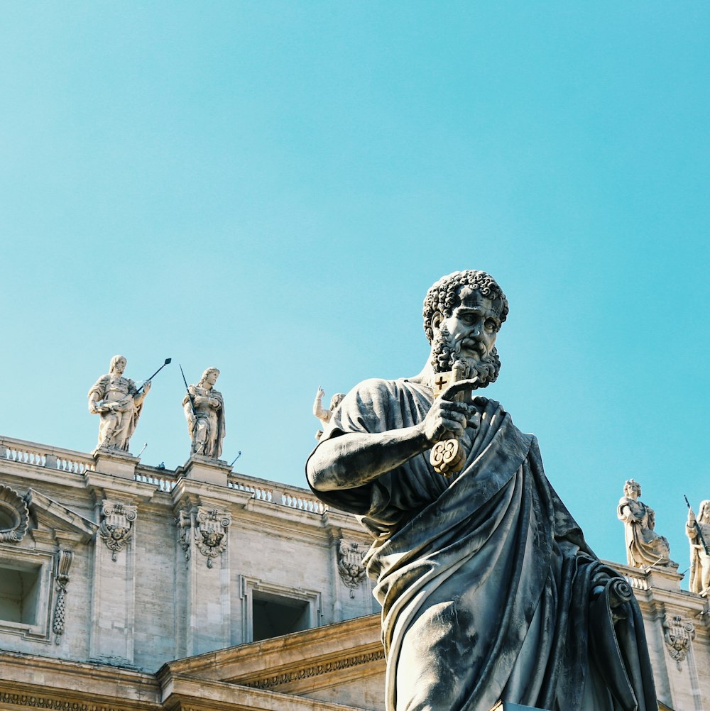 man in robe statue under blue sky during daytime