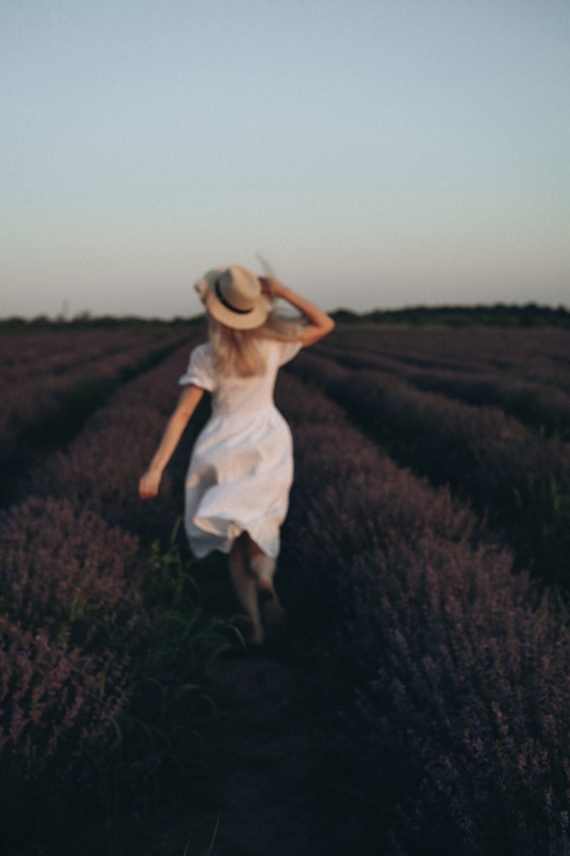 A woman in a white dress standing in a green field — representing healing and renewal