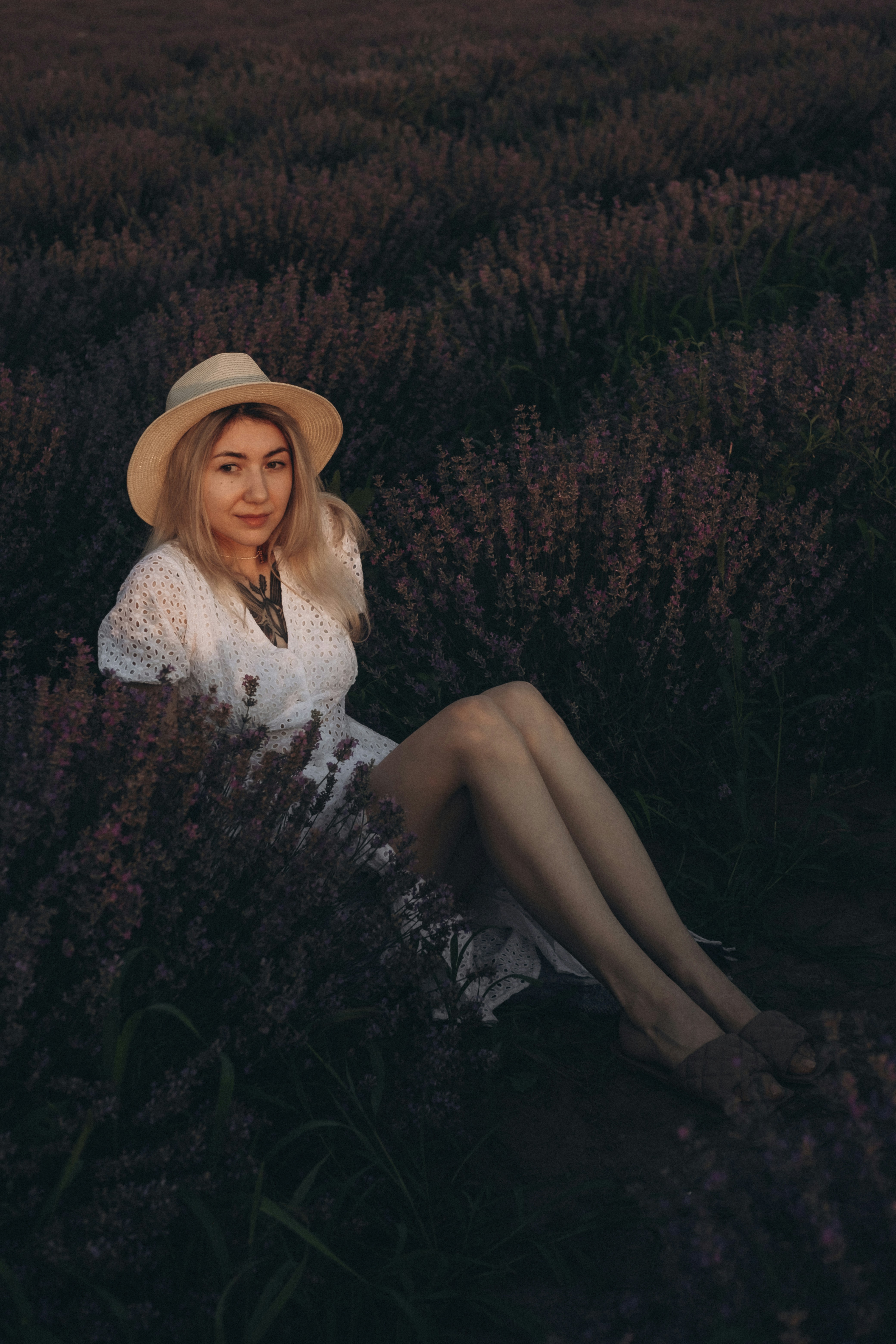 woman in white and black floral dress sitting on ground