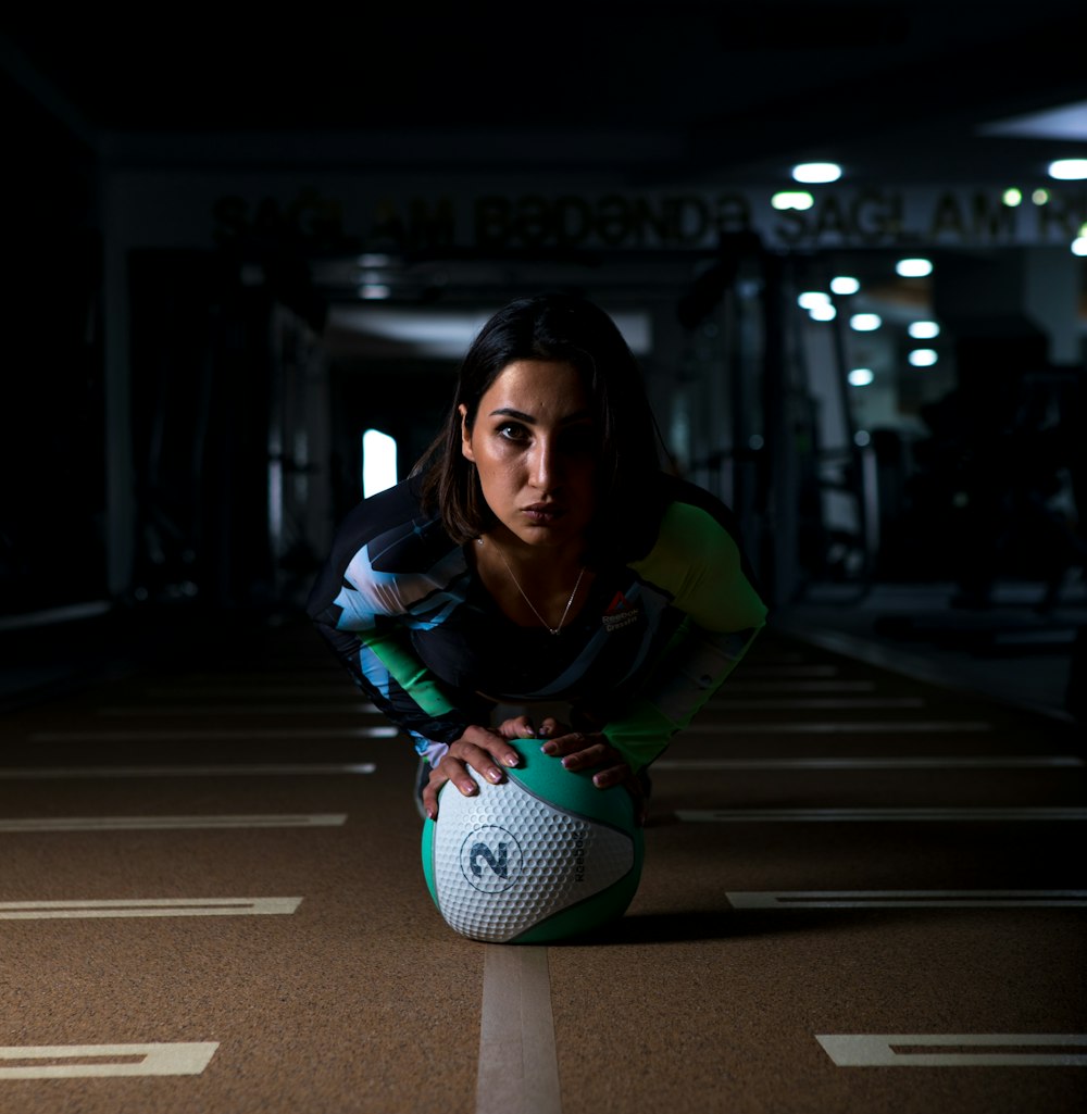 woman in green and white jacket holding green and white soccer ball