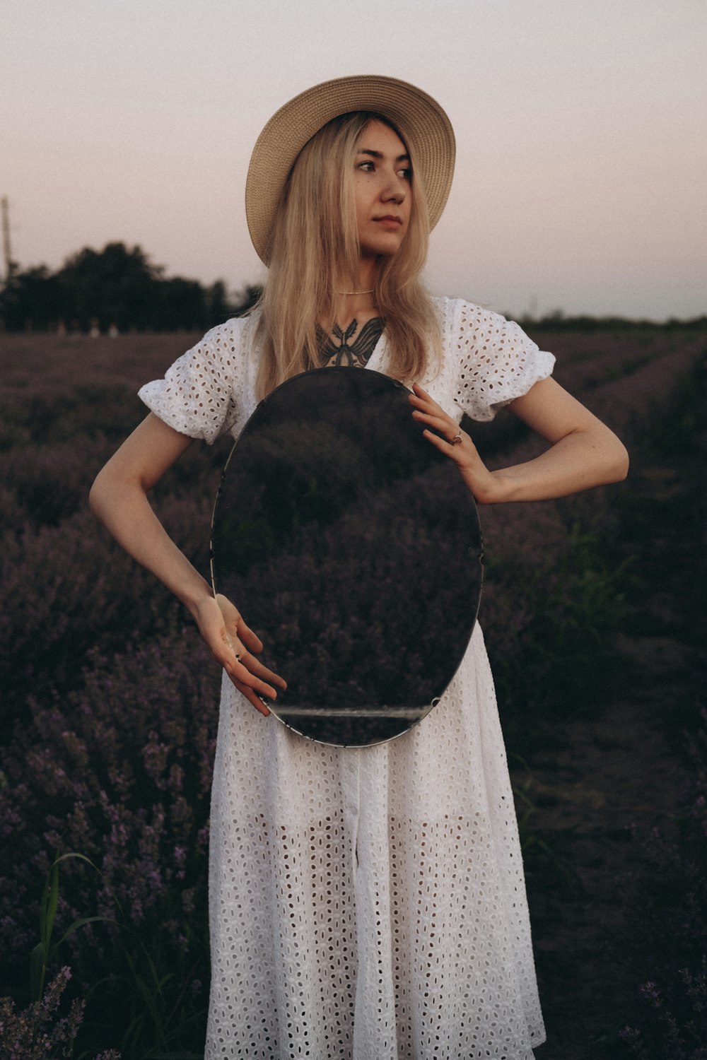 woman in white lace dress holding her hat