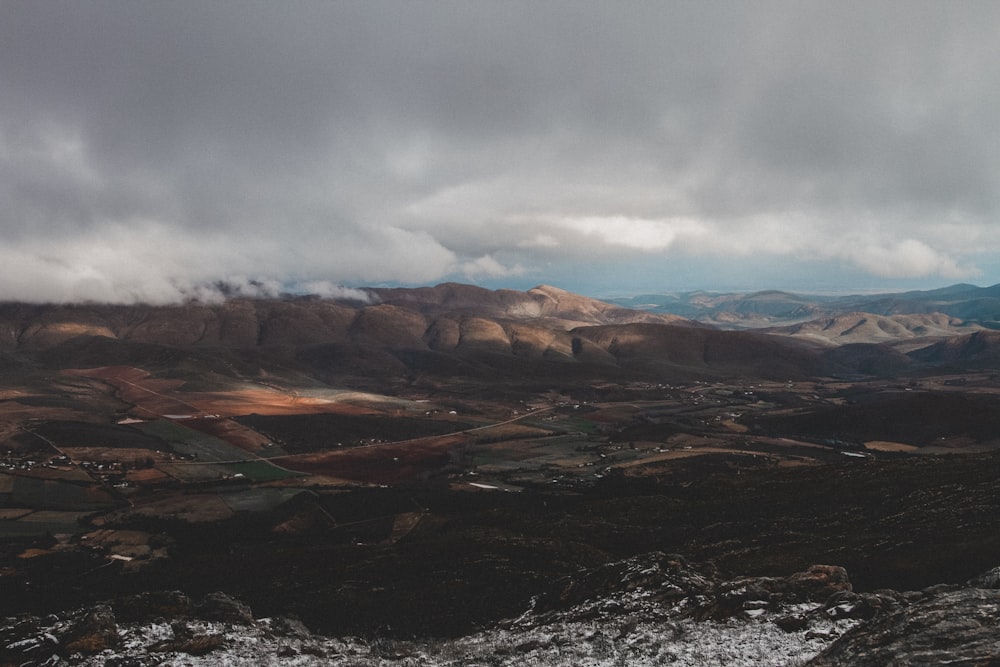 brown and gray mountains under gray clouds