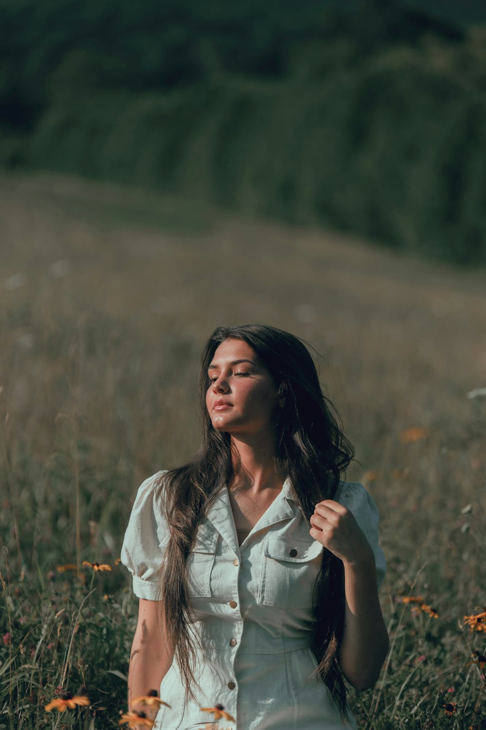 woman in white button up shirt standing on brown grass field during daytime