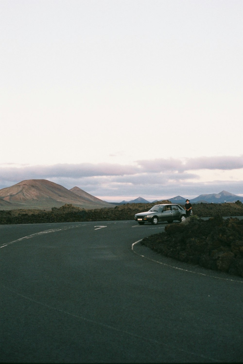 black car on road near brown mountain during daytime