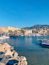 red and white boat on sea near brown rocks during daytime