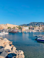 red and white boat on sea near brown rocks during daytime