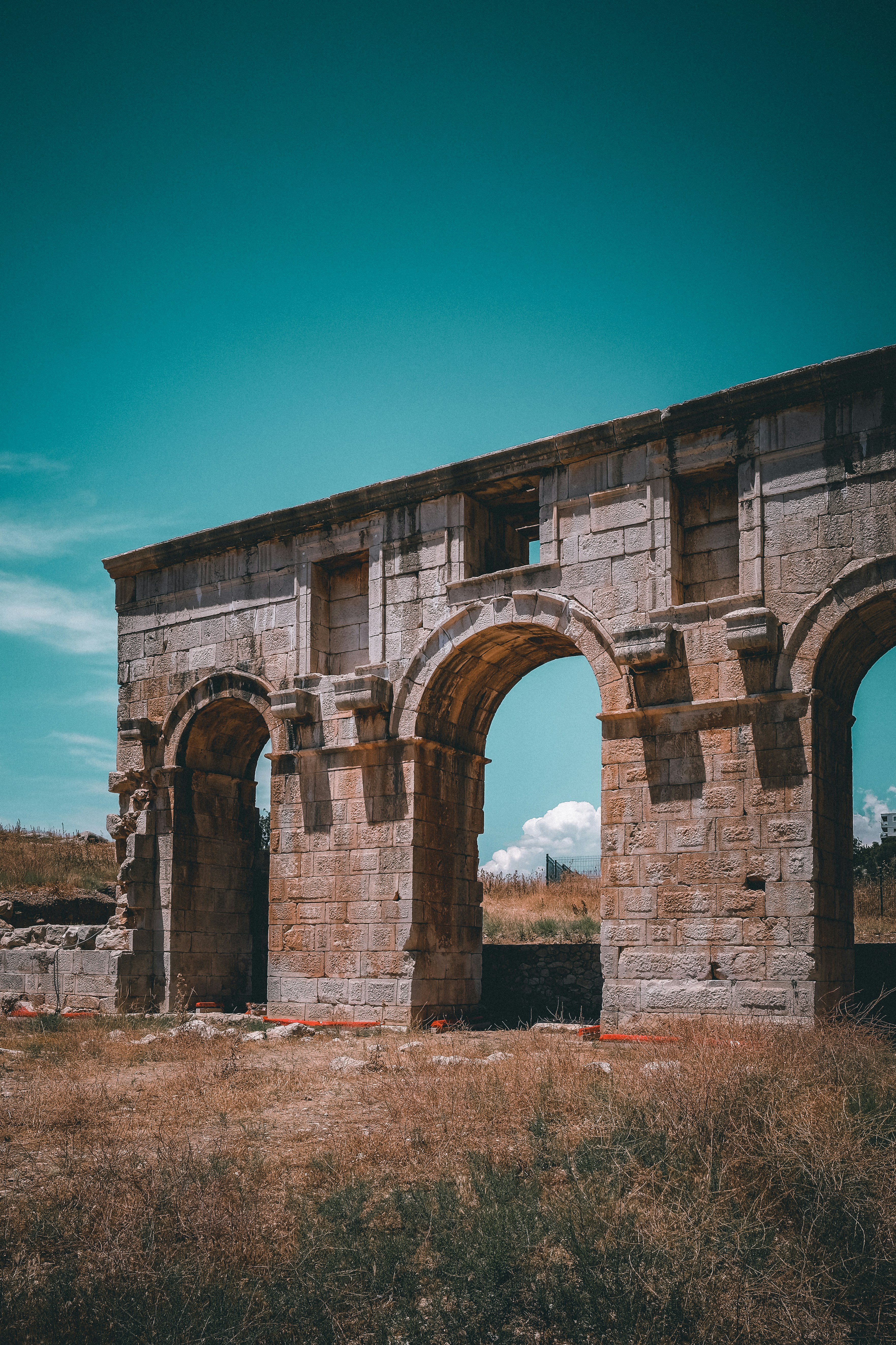 Arco di mattoni marrone sotto cielo blu durante il giorno