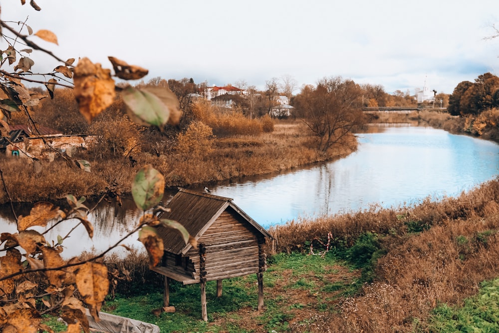 brown wooden house beside lake during daytime