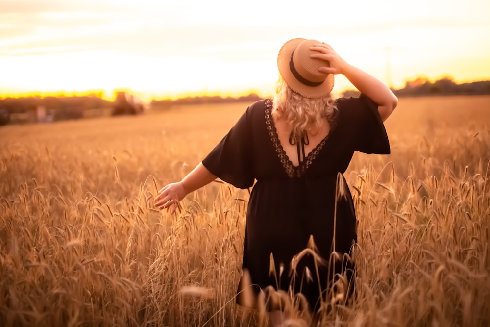 woman in black dress standing on brown grass field during daytime