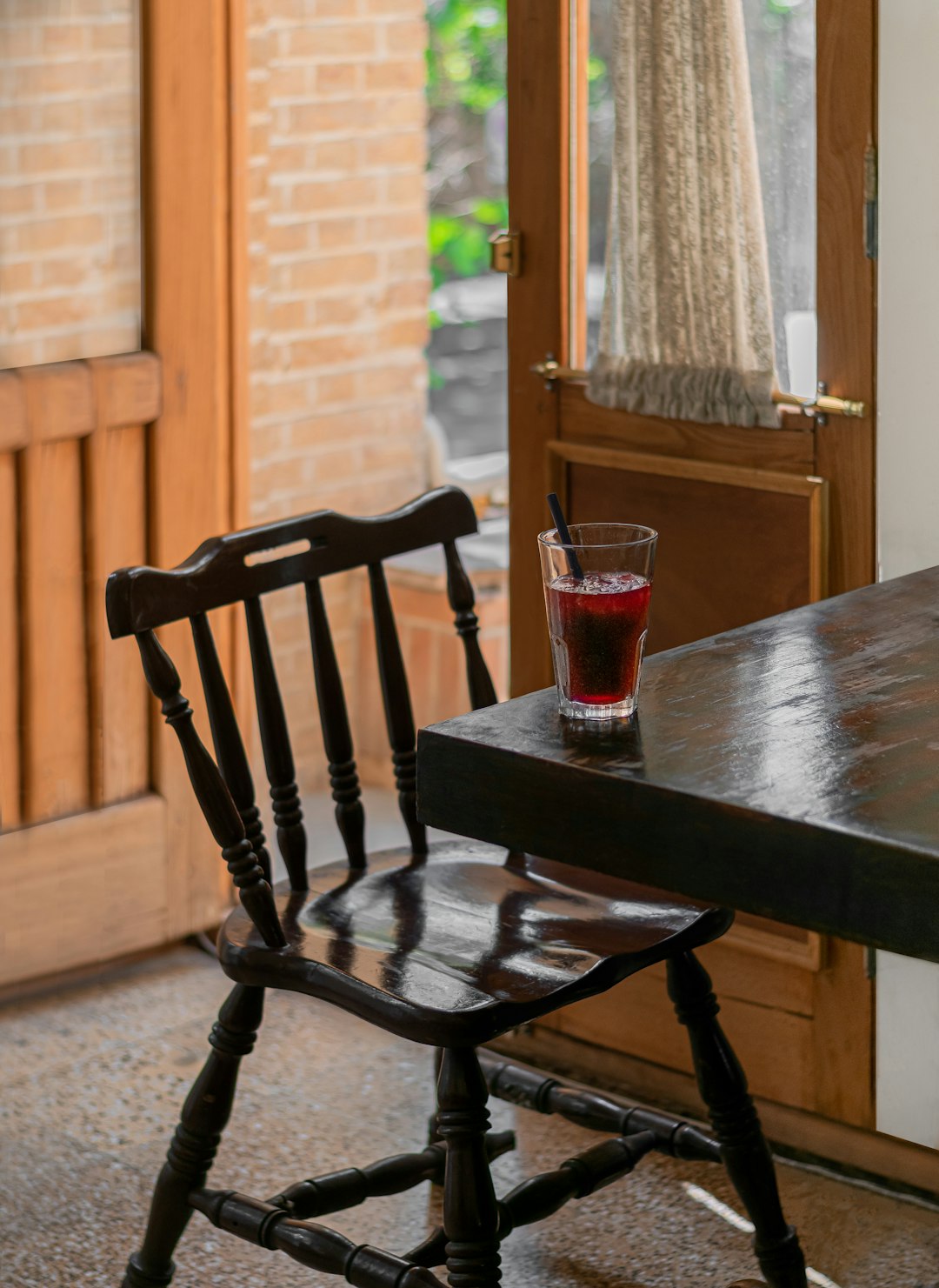 red drinking glass on brown wooden table