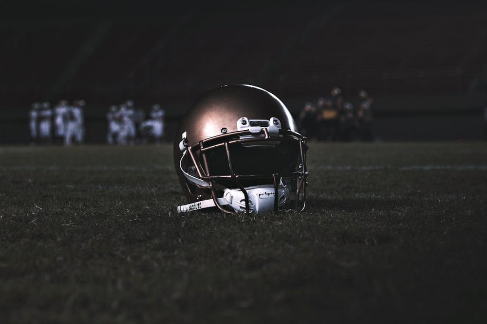 capacete de futebol no campo de grama verde durante a noite