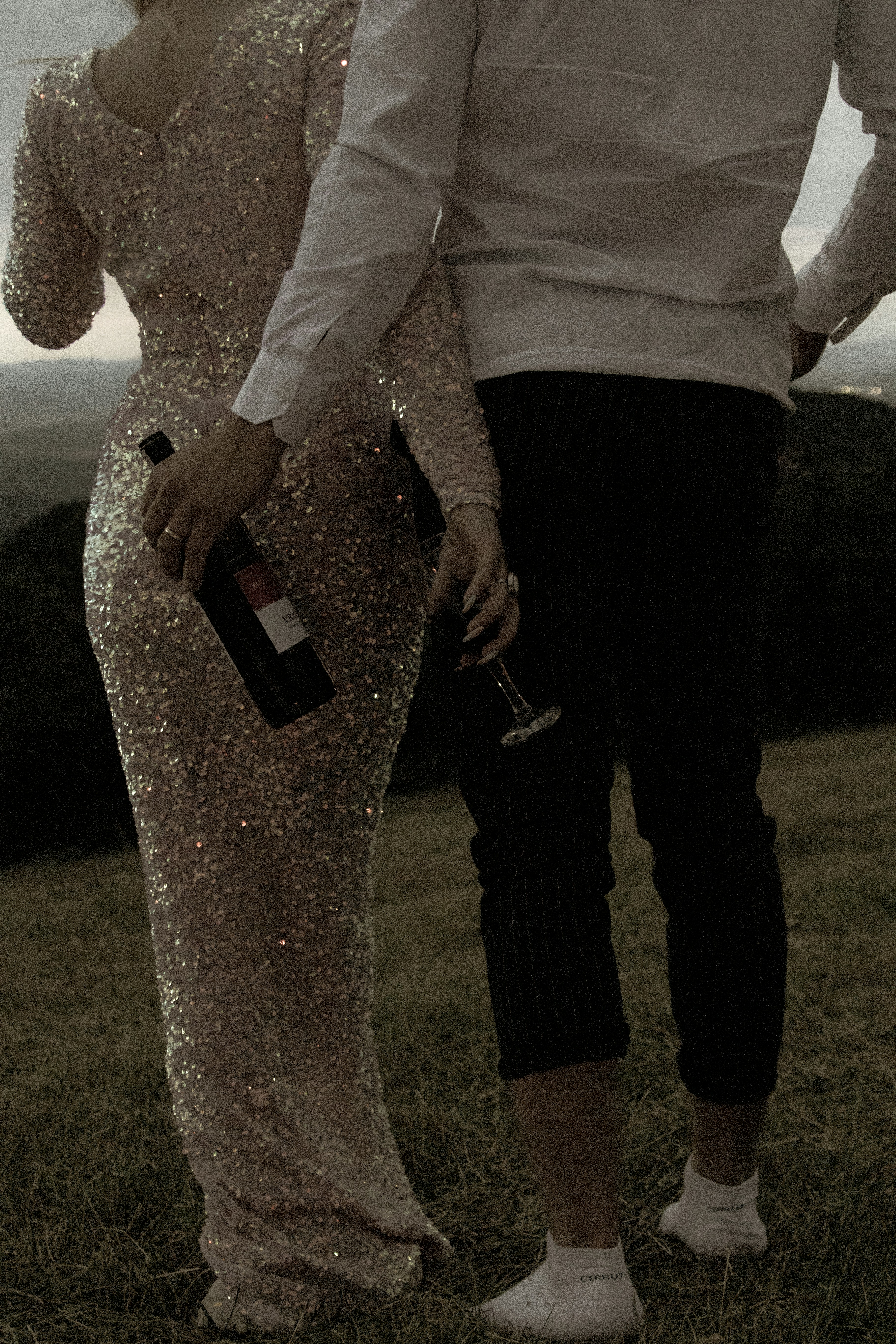 man and woman holding hands while walking on green grass field during daytime