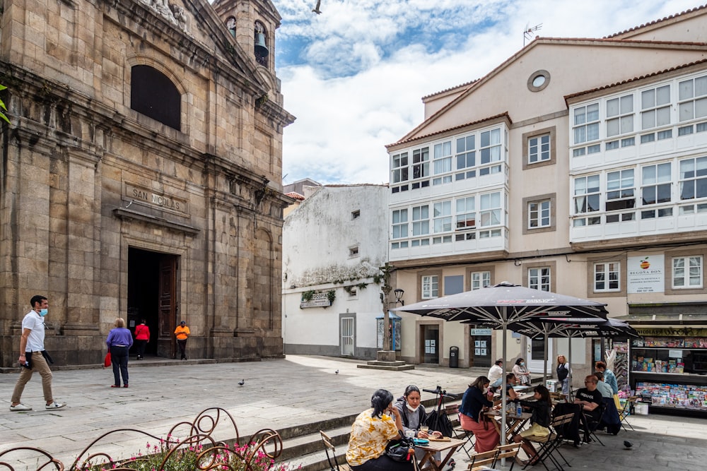 people sitting on bench near building during daytime