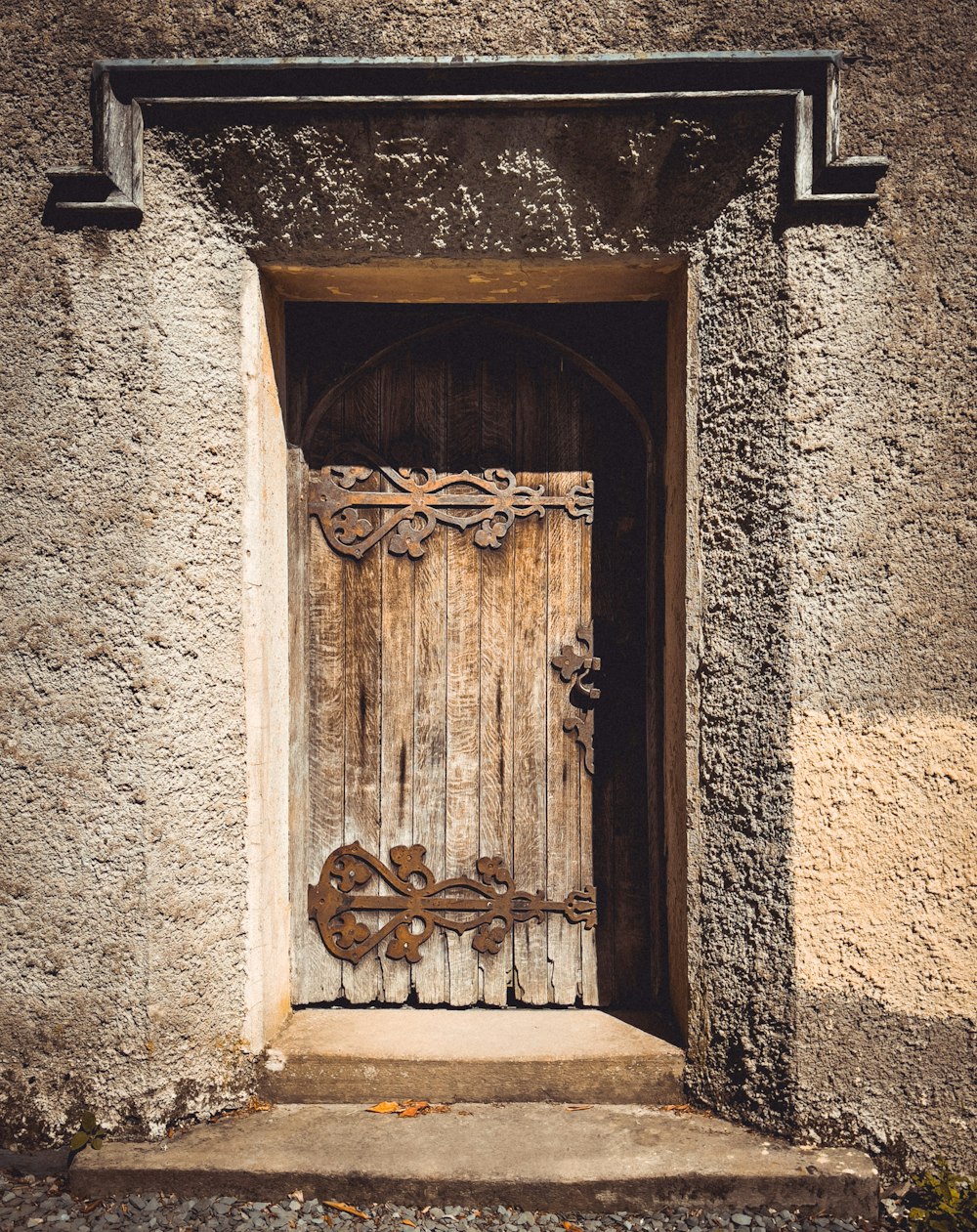 灰色のコンクリートの壁に茶色の木製のライオンのドア