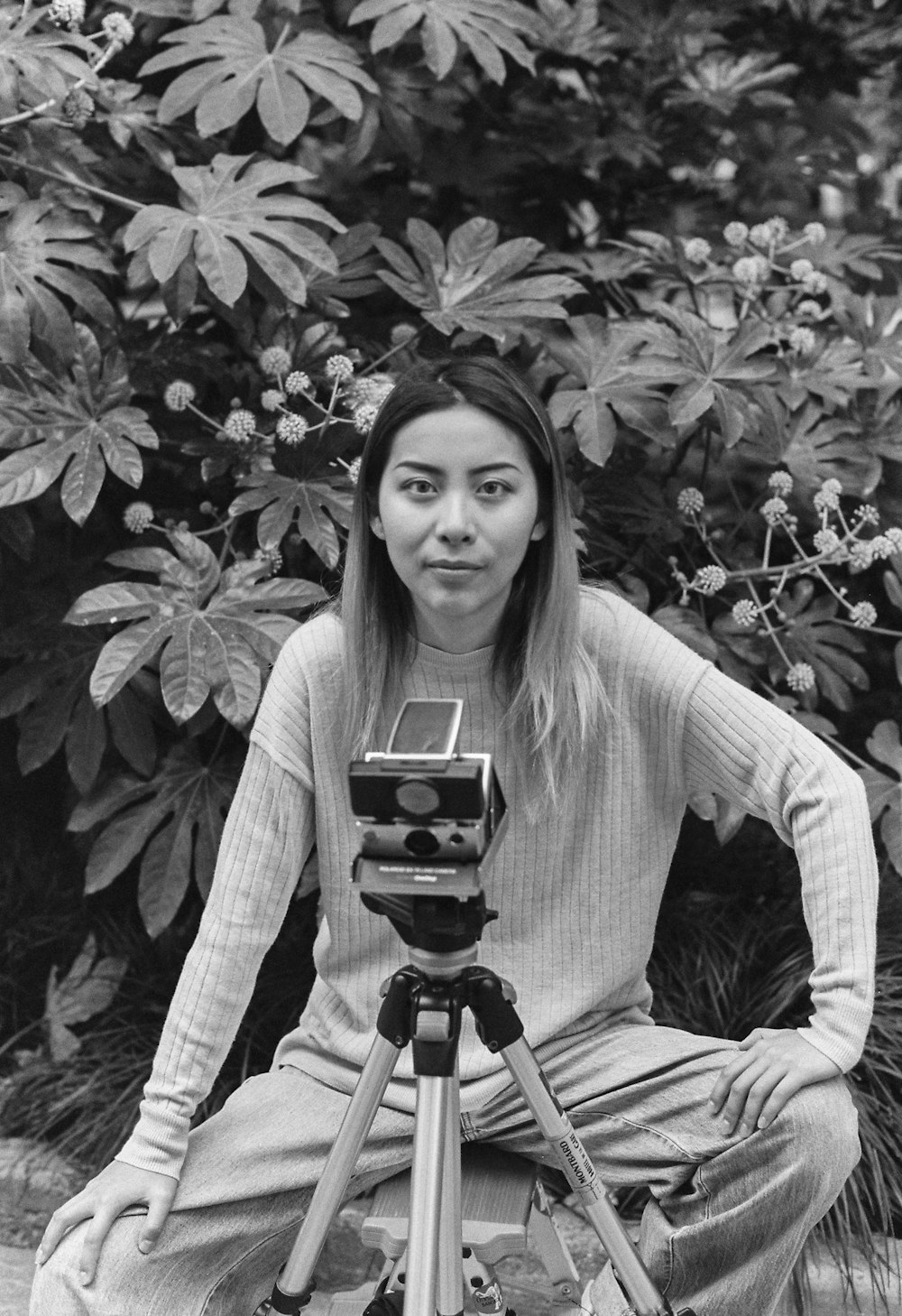 a black and white photo of a woman with a camera