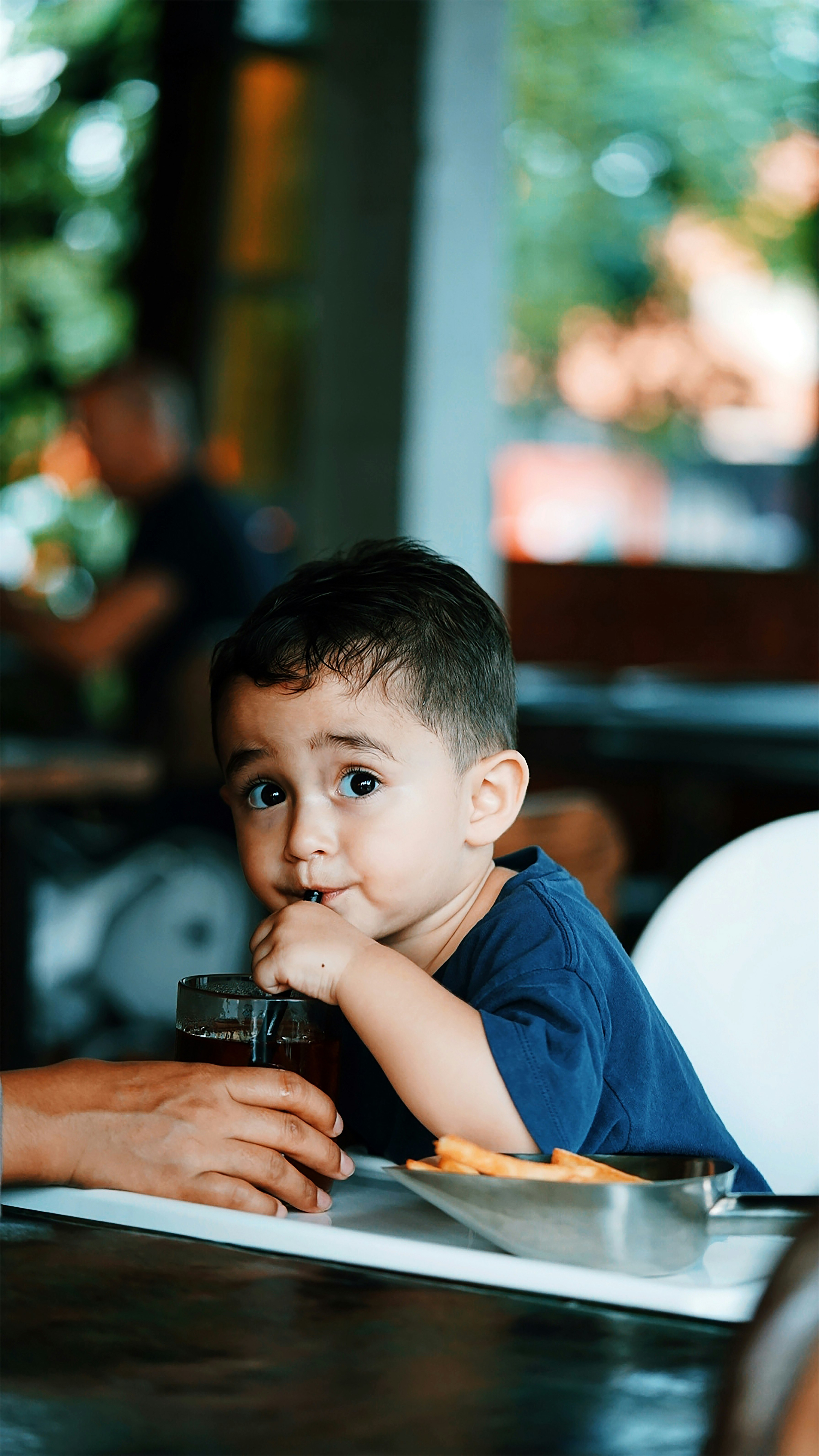 boy in blue crew neck t-shirt holding black camera