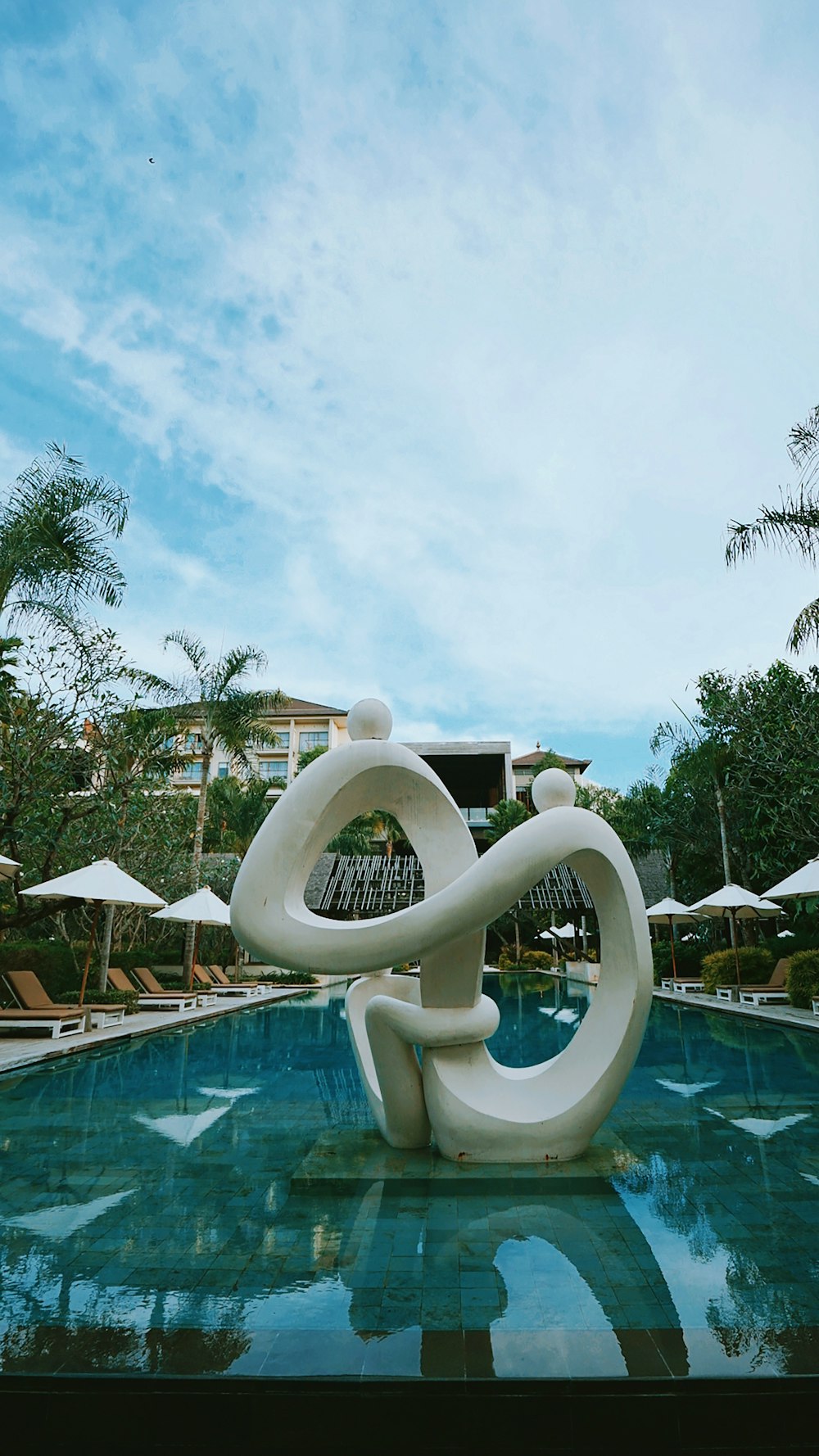 white swimming pool near green trees during daytime