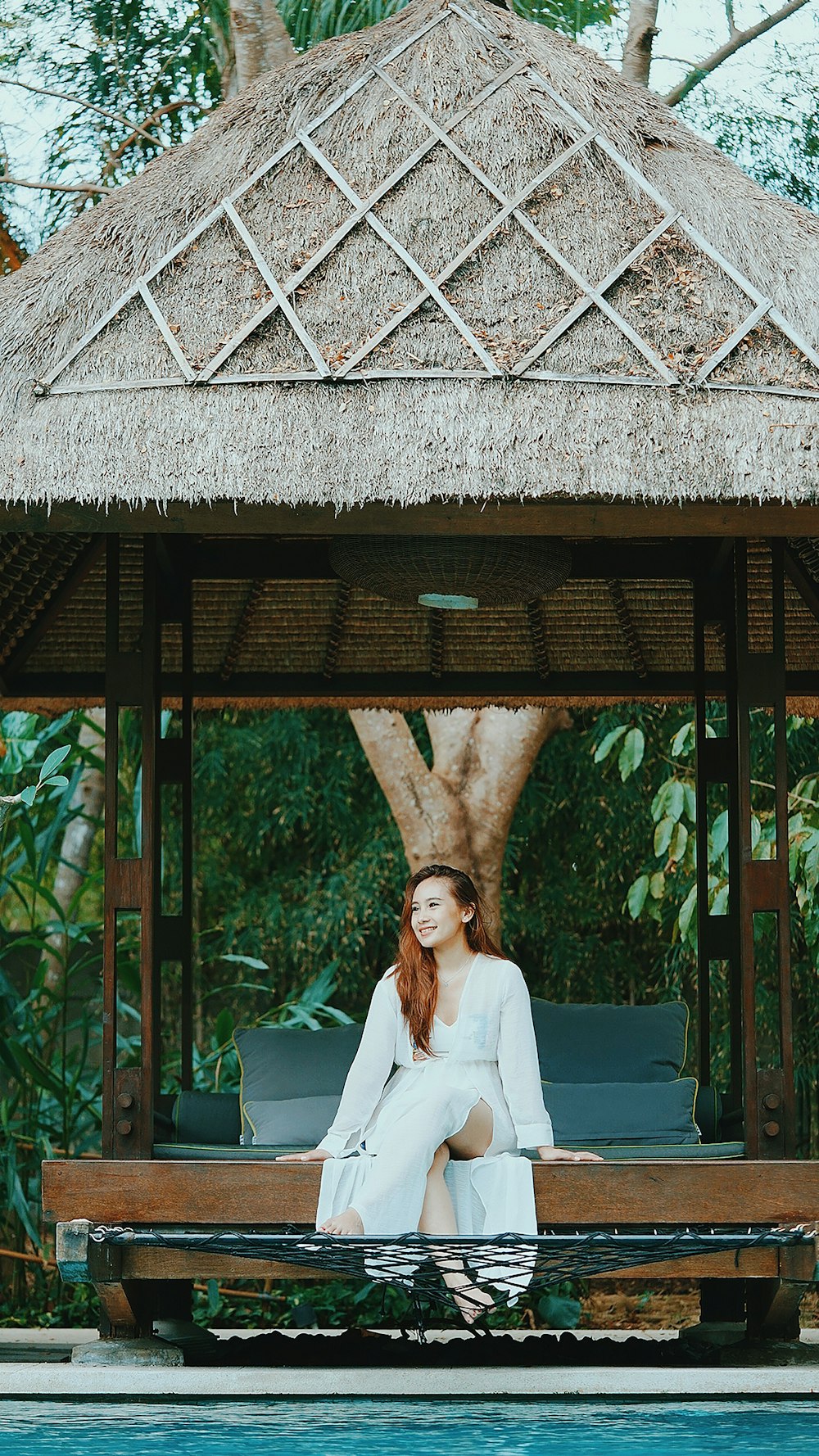 woman in white blazer standing under brown wooden roof