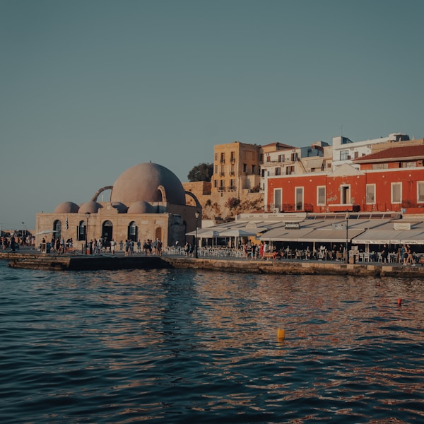 white and brown concrete building beside body of water during daytime