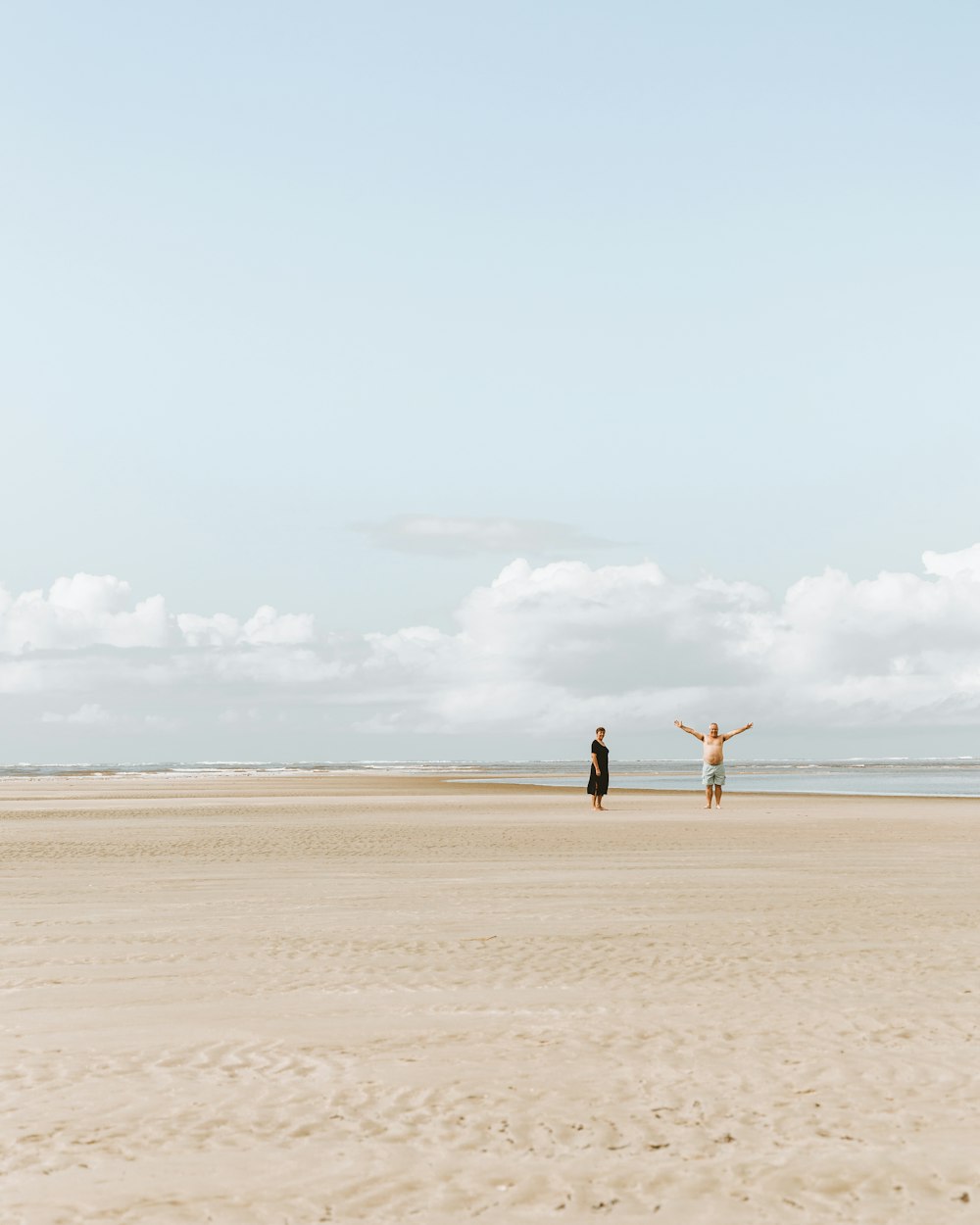 2 men walking on beach during daytime