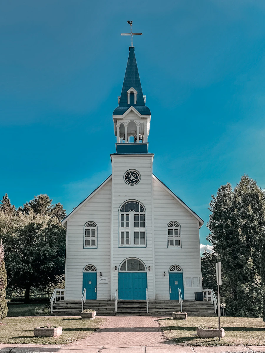 White and blue church building under a clear sky, welcoming and bright