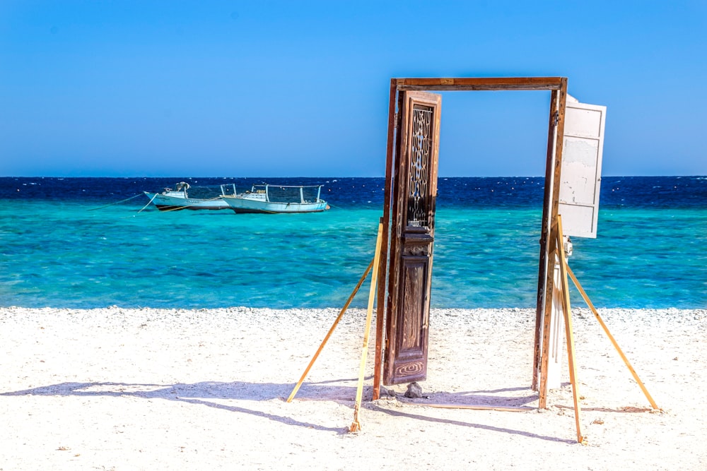 brown wooden frame on white sand beach during daytime