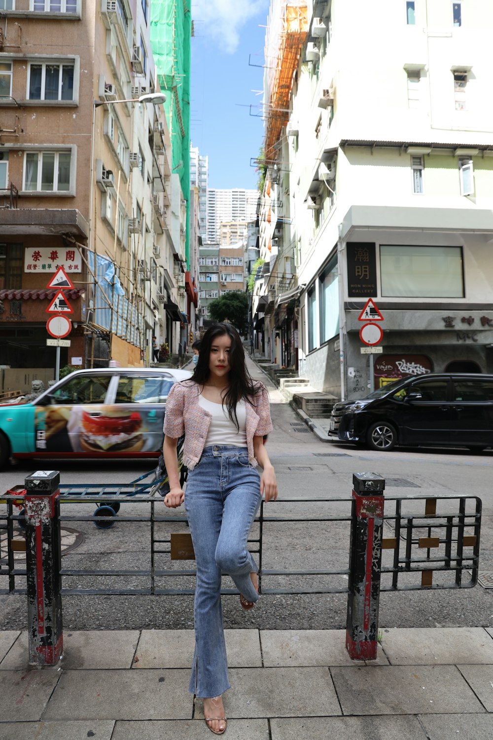 woman in blue denim jeans standing on red metal railings