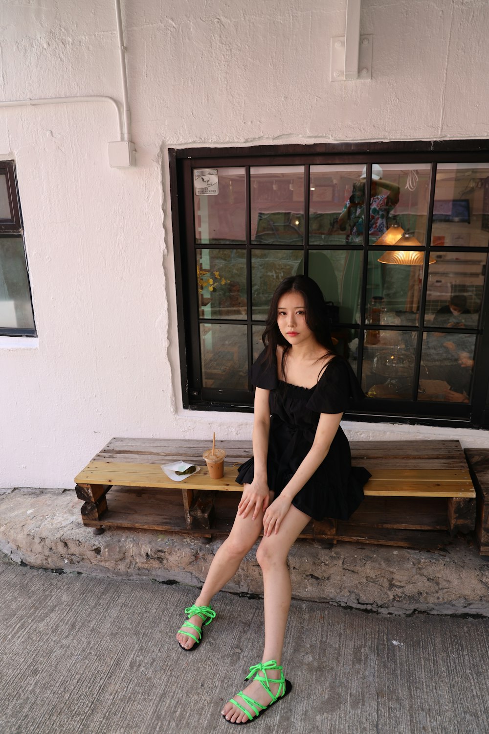 woman in black dress sitting on brown wooden bench