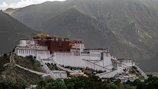 white and brown concrete building near mountain during daytime