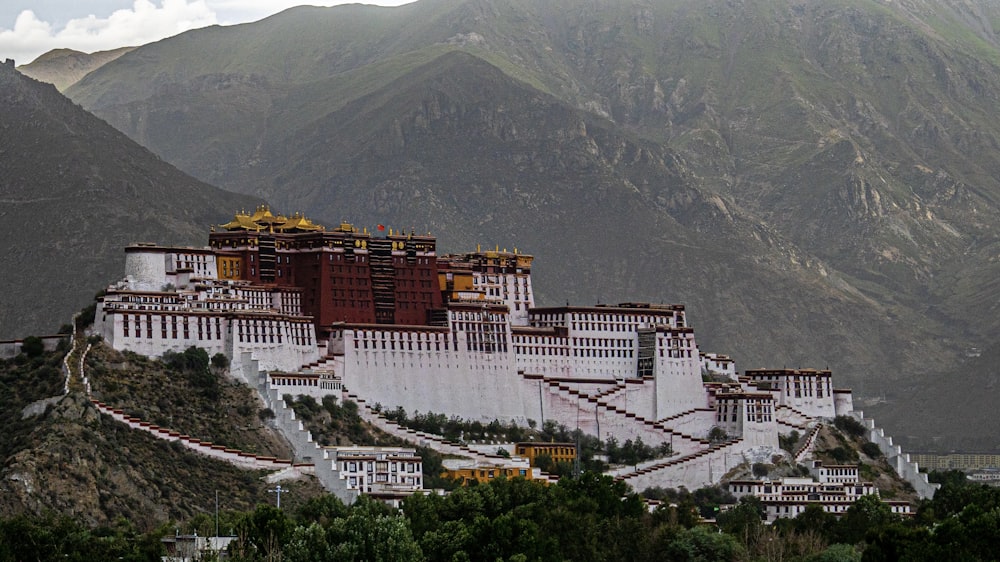 Edificio de hormigón blanco y marrón cerca de la montaña durante el día