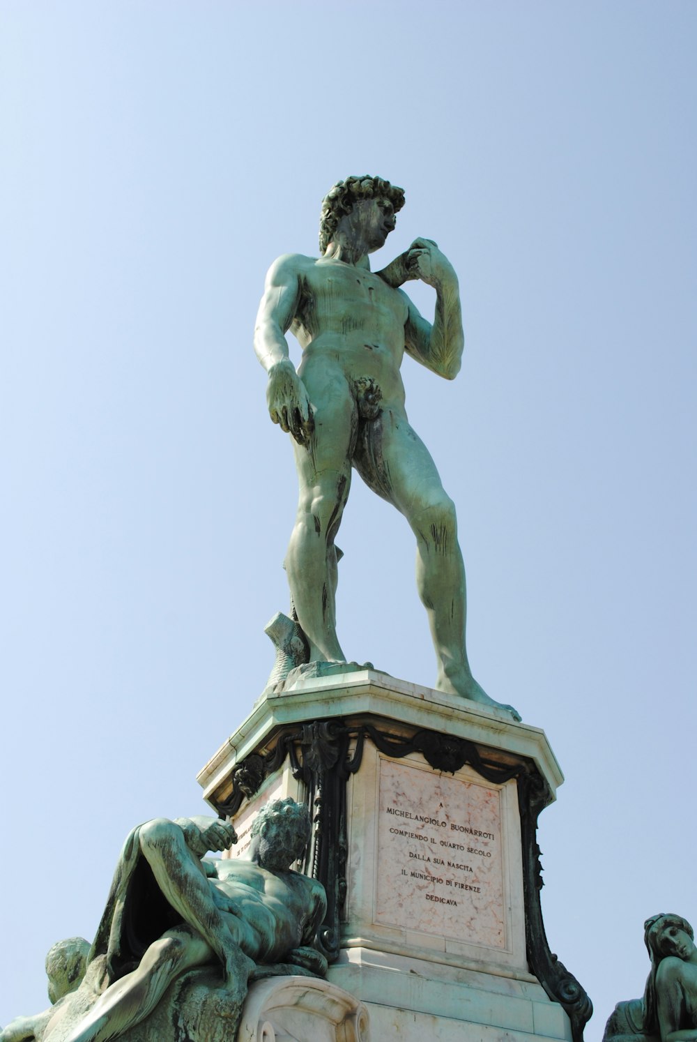 man holding a book statue