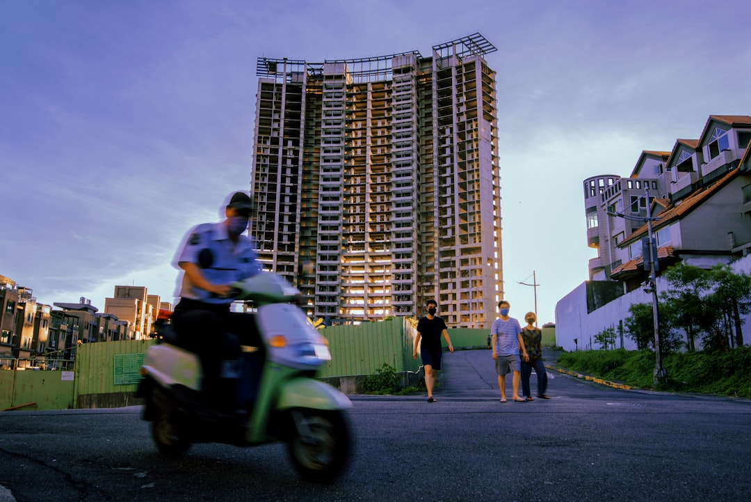 man in white shirt riding green motorcycle on road during daytime