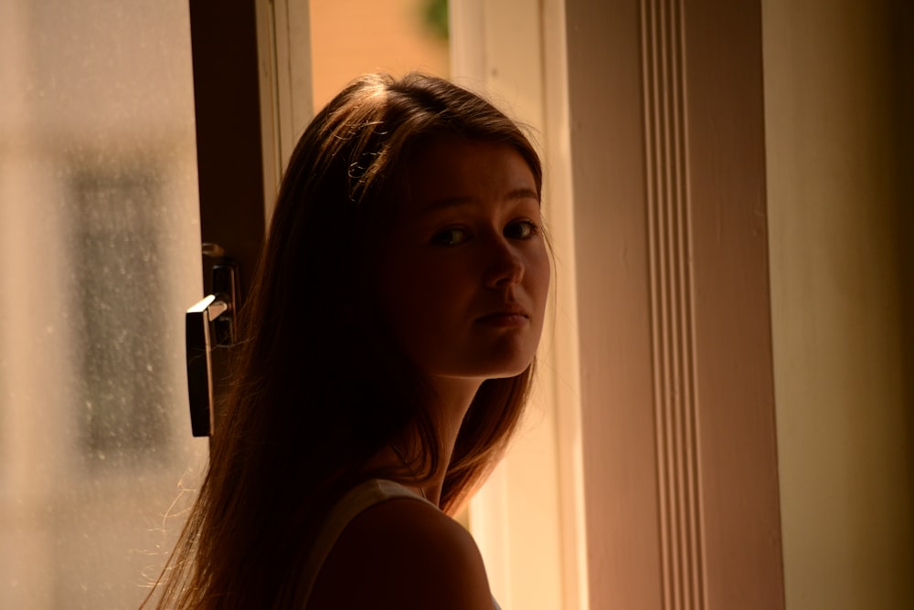 a woman standing in front of a window