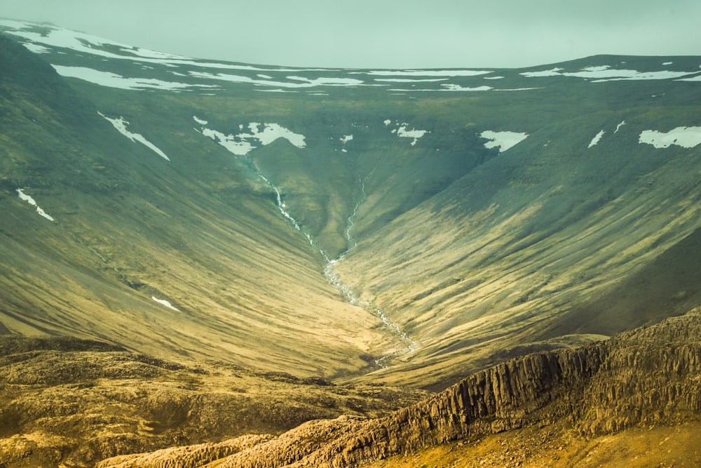 brown and green mountains under gray sky