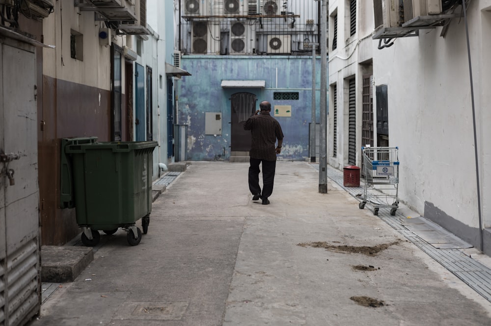 person in black jacket walking on sidewalk during daytime