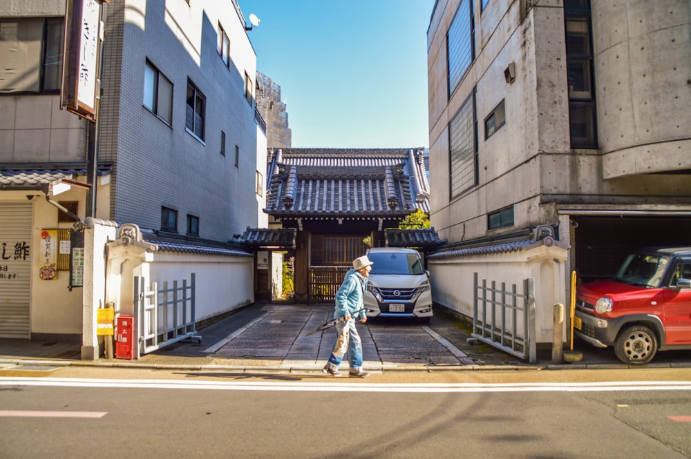 man in white shirt and blue denim jeans riding on bicycle on road during daytime