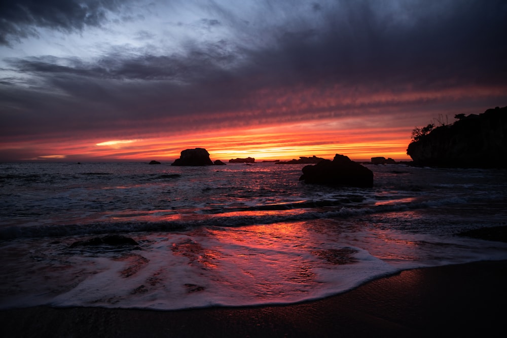 body of water under cloudy sky during sunset