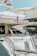 Several luxurious yachts are docked in a marina. One of the yachts prominently features an American flag and has the name 'The Pearl' written on it. The yachts are equipped with various amenities and have a sleek, modern design.