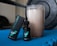 A bottle of Resilience CBD oil, labeled 'Citron Zest', is positioned next to its packaging box on a blue exercise mat. Beside it, there is a shaker filled with a light-colored drink. In the background, there is a blurred fitness weight, suggesting a workout setting.