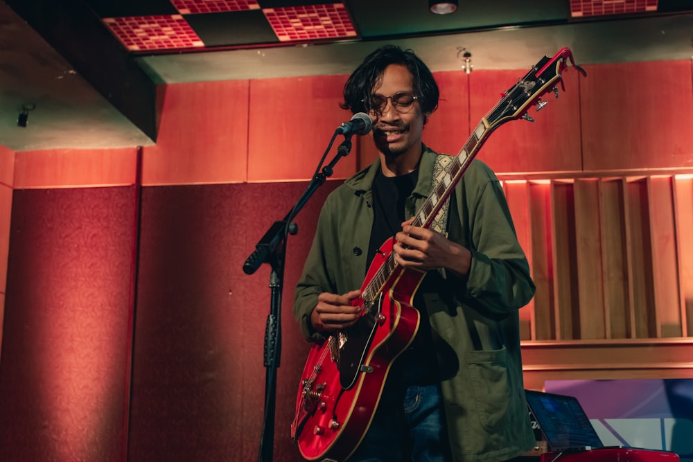 man in brown jacket playing electric guitar