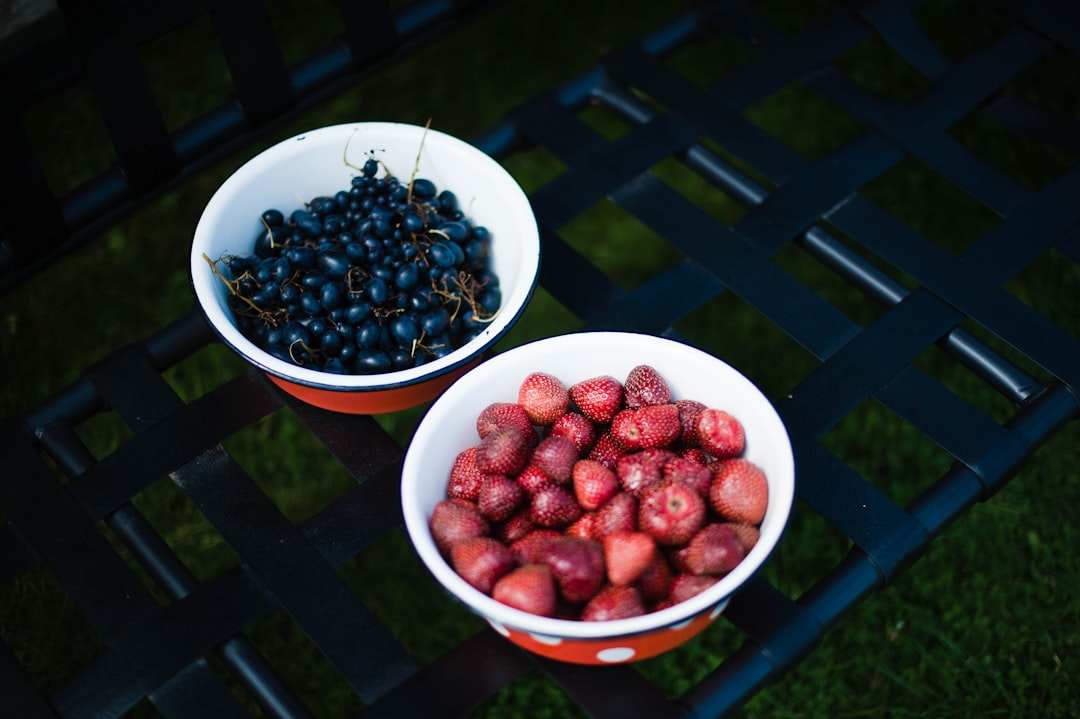 red and black berries in white ceramic bowl