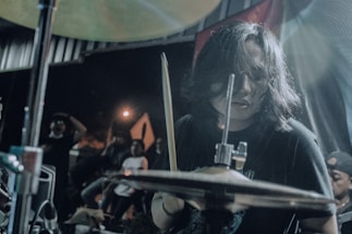 A close-up photo of David El Gringo playing percussion with passion on stage.