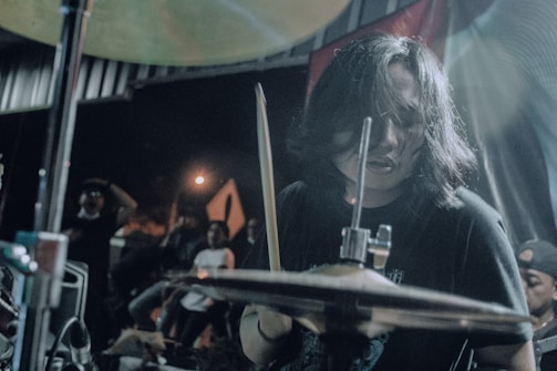 A close-up photo of David El Gringo playing percussion with passion on stage.