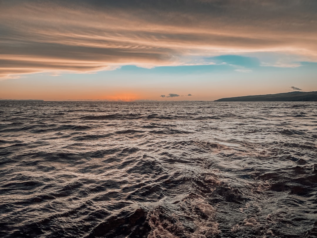 ocean waves crashing on shore during sunset